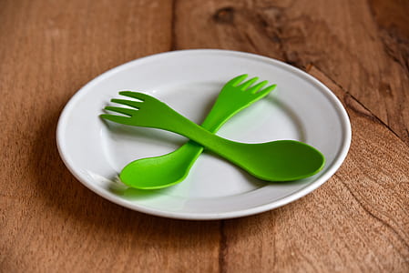 green plastic spoon and fork on top white plate thumbnail