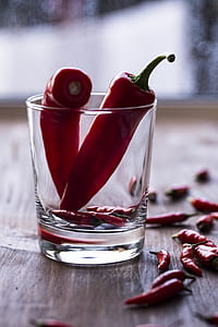 selective focus photography of two red chilies inside clear drinking glass thumbnail