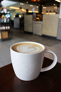 Cup of hot coffee in Starbucks with logo on the cup. Editorial use only. thumbnail