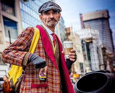 man in red and white plaid coat holding white spill-proof cup thumbnail