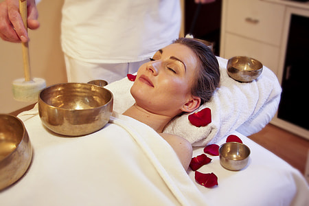 woman lying on white massage table near person thumbnail