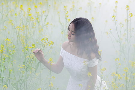 woman wearing white off-shoulder dress holding yellow flower thumbnail