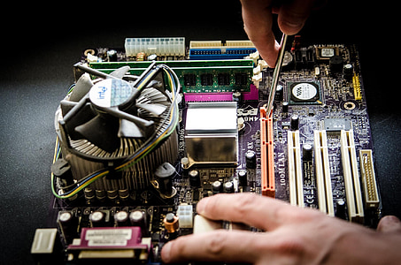 person holding screw fixing multicolored computer motherboard thumbnail