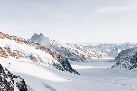 mountain alps and valley under calm sky thumbnail