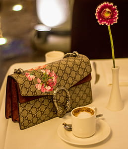 Gucci fold-over bag beside teacup on saucer thumbnail