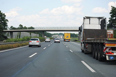 gray truck travelling on road at ride side during daytime thumbnail