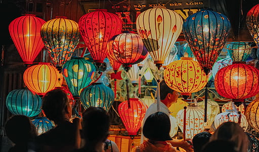 People Standing Near Assorted-color Lamps thumbnail