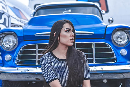 photo of woman sitting in front of blue car thumbnail