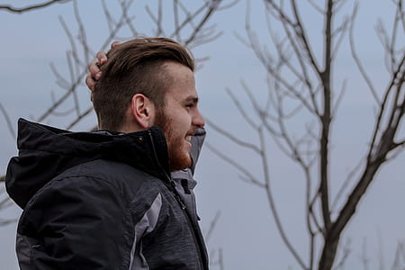 man standing near bare tree thumbnail