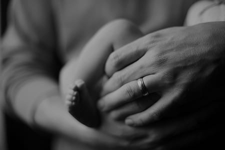 grayscale photo of person carrying baby thumbnail