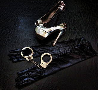 photo of pair of gold-colored spike studded sandals, handcuffs, and spandex gloves both on black surface thumbnail
