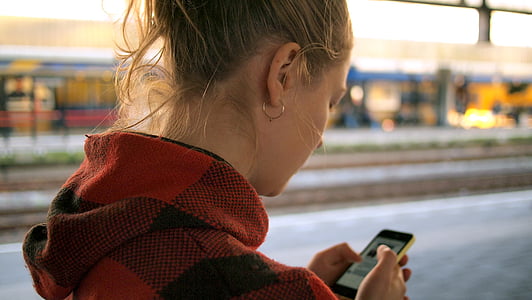 woman using her phone during daytime thumbnail