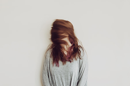woman in grey long-sleeved top waving her hair thumbnail