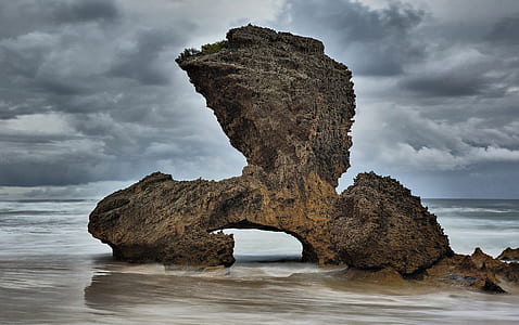 rock formation under cloudy sky at daytime thumbnail