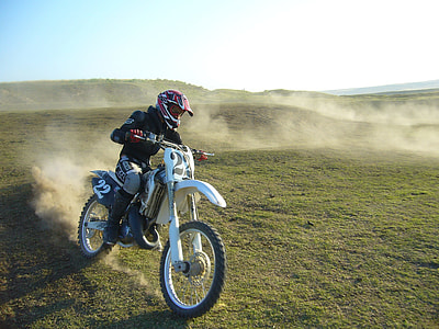 man ridding motocross dirt bike drifting on sand thumbnail