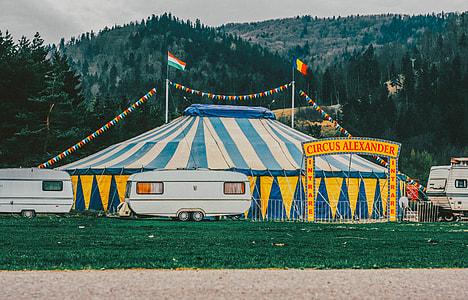photo of camper trailer parked near carnival tent during daytime thumbnail