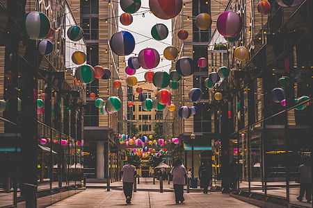 group of people between building with assorted-color ball decals thumbnail