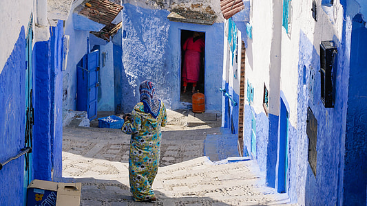 woman in teal and beige dress near blue wall thumbnail