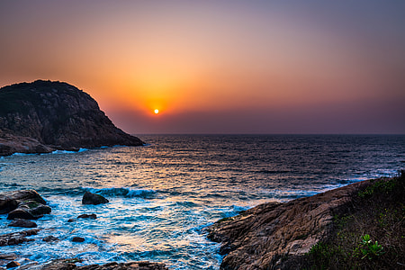 landscape photography of rock formations surrounded with body of water during golden hour thumbnail