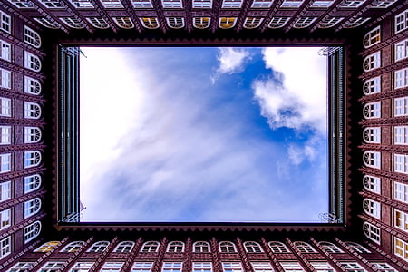 white clouds above a brown building thumbnail