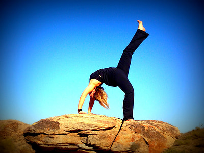 woman doing yoga post on rock formation thumbnail