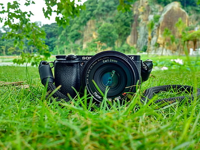 black Sony Alpha camera on green grass in close-up photography thumbnail