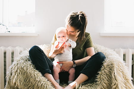 Woman Holding Baby While Sitting on Fur Bean Bag thumbnail