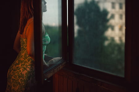 woman looking outside her window thumbnail