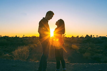 couple facing each other near trees at golden hour thumbnail