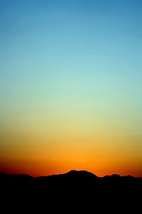 Silhouette of Mountain Under Orange and Blue Sky during Sunset thumbnail