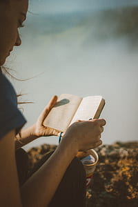 woman reading booklet at daytime thumbnail