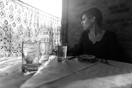 woman in black sweater near on clear glass bottles thumbnail