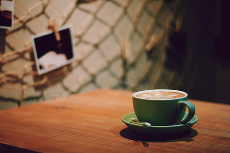 selective focus photo of blue ceramic teacup on brown wooden table thumbnail