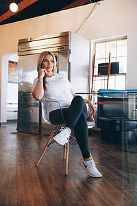 woman wearing white crew-neck t-shirt and black leggings setting on armchair thumbnail