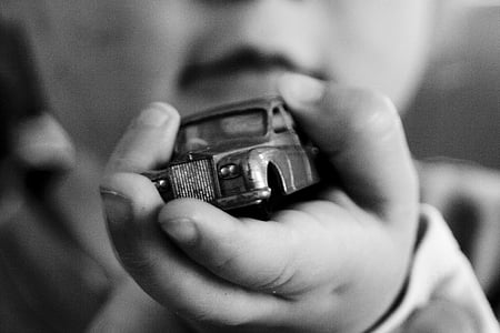 graycale photography of toddler holding car toy thumbnail