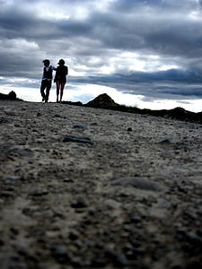 couple walking under gray sky during daytime thumbnail
