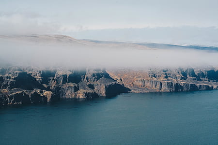 aerial photography of body of water beside mountains during daytime thumbnail