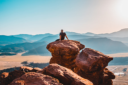 man wearing black t-shirt on boulders at daytime thumbnail