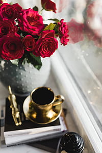 Gold cup of coffee and red roses bouqet thumbnail