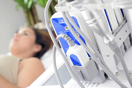 person lying on bed near white and blue machine thumbnail