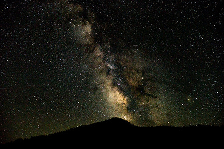 silhouette mountain under milky way sky at night time thumbnail