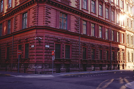 red wall paint building near road during daytime thumbnail