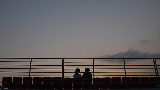 silhouette of two person's sitting on bench thumbnail