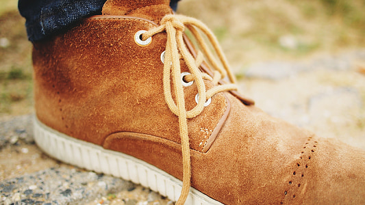 person wearing brown suede ankle boot in close-up photography thumbnail