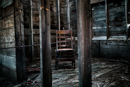 empty wooden chair inside abandoned building room thumbnail