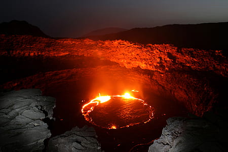 red flame on body of water near cliff during night time thumbnail