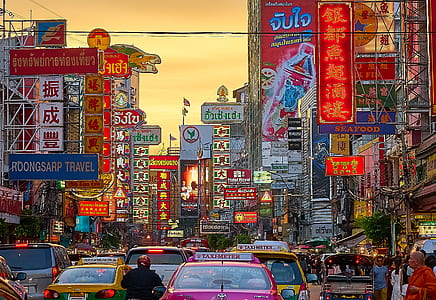 assorted-color-and-type vehicle on road traffic in between buildings thumbnail