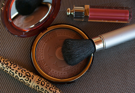 brown pressed powder and gray makeup brush on gray textile thumbnail