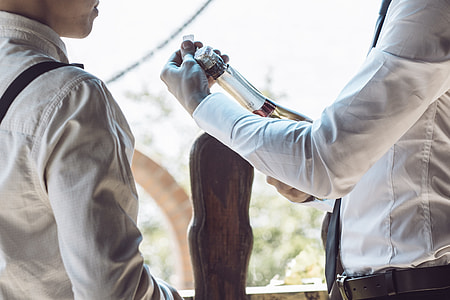 person holding bottle near another person thumbnail