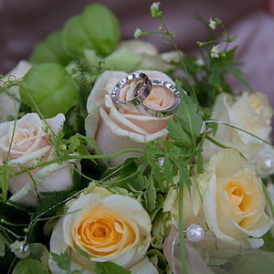 pair of silver-colored rings on flower buoquet thumbnail